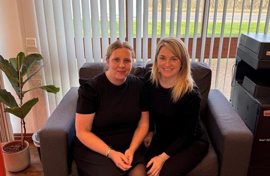 Aleana Mitchell and Isobel Forber sitting together in the Coopers&Co office, representing their support for small business owners in managing financial well-being and mental health