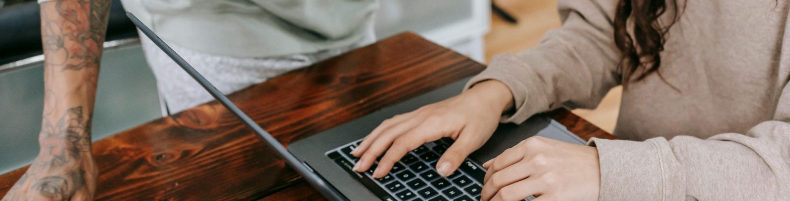 Small business owner using laptop for Making Tax Digital setup with coffee in hand