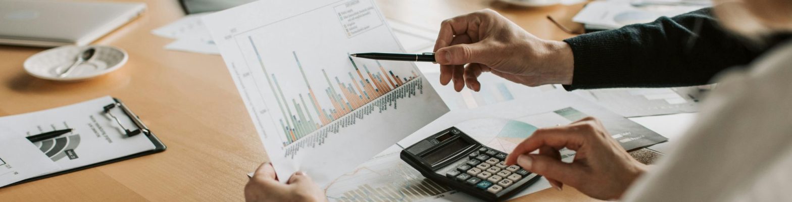 Business professionals reviewing financial graphs and forecasts during a planning meeting. Photo by Vlada Karpovich via Pexels.